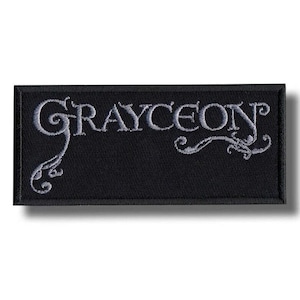 May include: A rectangular black patch featuring the embroidered word "GRAYCEON" in a light grey, stylized font. The design incorporates decorative flourishes on either side of the text. The patch is bordered in black.