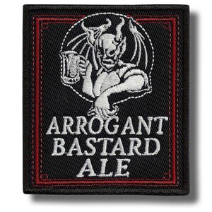 Pode incluir: Patch bordado preto com borda vermelha. Apresenta uma ilustração branca de um diabo segurando uma caneca de cerveja, com o texto "ARROGANT BASTARD ALE" bordado em branco abaixo.