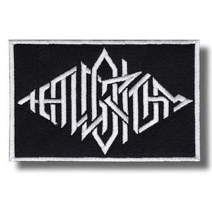 May include: Black rectangular patch featuring white embroidered text. The text is a stylized, geometric design with sharp angles and a diamond shape. The patch has a white border and a shadow.