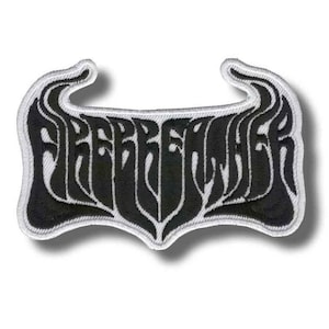 以下が含まれることがあります： 「FREEBREAKER」の文字がスタイリッシュなフォントで刺繍された白黒のパッチ。パッチは上部と下部が湾曲しており、白い縁取りがあります。