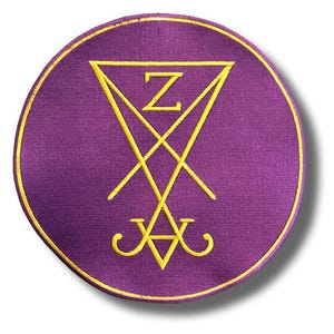 Puede incluir: Parche circular morado con borde dorado. El parche presenta un diseño de sigilo amarillo con un triángulo, líneas que se cruzan y la letra "Z". El diseño tiene una apariencia estilizada y simétrica.