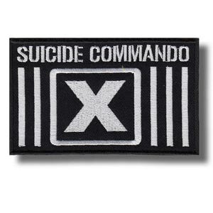 Könnte beinhalten: Schwarzer rechteckiger Aufnäher mit dem weißen Schriftzug "SUICIDE COMMANDO". Er zeigt ein weißes "X" in einem weißen Quadrat und drei weiße vertikale Linien auf jeder Seite des Quadrats.