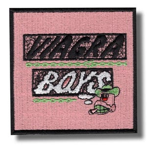 Puede incluir: Parche bordado con las palabras "VIAGRA BOYS" en blanco y negro sobre un fondo rosa. Un personaje de dibujos animados con sombrero de vaquero y cigarrillo aparece en la esquina inferior derecha. El parche tiene un borde negro.