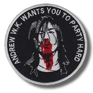 Könnte beinhalten: Runder schwarzer Aufnäher mit weißem Text: "ANDREW W.K. WANTS YOU TO PARTY HARD." Der Aufnäher zeigt eine Schwarz-Weiß-Illustration einer Person mit rotem Blut, das aus Nase und Mund tropft.