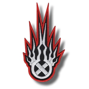 May include: Embroidered patch with a flame design in red, white, and black. The flame design incorporates a circular emblem with a cross. The patch has a black border and is suitable for clothing or accessories.