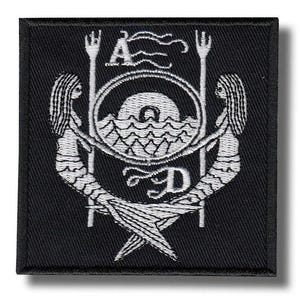 May include: Black square patch with a white embroidered design. The design features two mermaids holding tridents, flanking a circular emblem with waves and the letters "A" and "D". The mermaids' tails cross at the bottom.