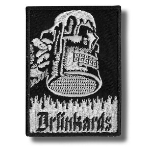 May include: Black embroidered patch featuring a white design of a person holding a beer stein with foam spilling over. The word "Drunkhards" is embroidered in white script below the image. The patch is rectangular.