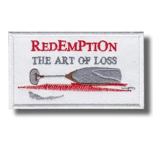 Peut inclure: Écusson brodé avec les mots "Redemption" en rouge et "The Art of Loss" en gris. Le motif représente un verre de vin brisé avec des accents rouges, suggérant du vin renversé. L'écusson a un fond blanc et une bordure blanche.