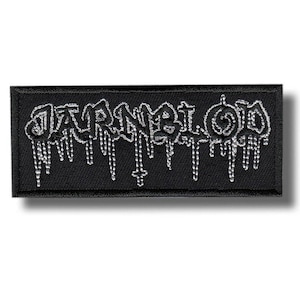 Könnte beinhalten: Schwarzer rechteckiger Aufnäher mit dem Wort "JARNBLOOD" in silberner, tropfender Schrift. Der Aufnäher hat ein kleines Kreuz am unteren Ende der Tropfen. Für eine Jacke oder Tasche.