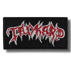 May include: A rectangular black patch with the word "Toked Up" embroidered in red and white. The text has a stylized, gothic font with a dripping effect, creating a bold and edgy design. The patch is likely for clothing or accessories.