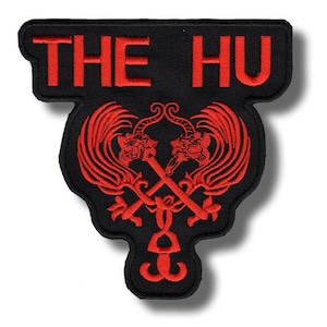 Pode incluir: Patch preto com design bordado em vermelho. O texto "THE HU" está no topo. Abaixo, um design simétrico apresenta duas figuras semelhantes a dragões com armas cruzadas e detalhes ornamentados. O patch tem uma forma única com bordas arredondadas.