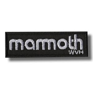 Puede incluir: Un parche rectangular negro con texto bordado en blanco que dice "mammoth" sobre "WVH" y "HAM". El parche tiene una apariencia texturizada y probablemente está diseñado para ser cosido en ropa o accesorios.
