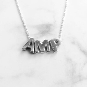 以下が含まれることがあります： AMPと刻まれたシルバーネックレス