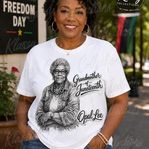 May include: A white short-sleeved t-shirt featuring a black and white sketch of Opal Lee with the text Grandmother of Juneteenth and Opal Lee. The shirt has a crew neckline and a graphic print centered on the chest area, showcasing a detailed portrait.