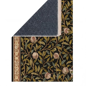 a close-up view of a rug with a floral pattern, including leaves and pomegranate fruits. The rug appears to be made of a dark-colored material, possibly wool or a similar fabric. The image does not contain any text or other discernible objects or actions.