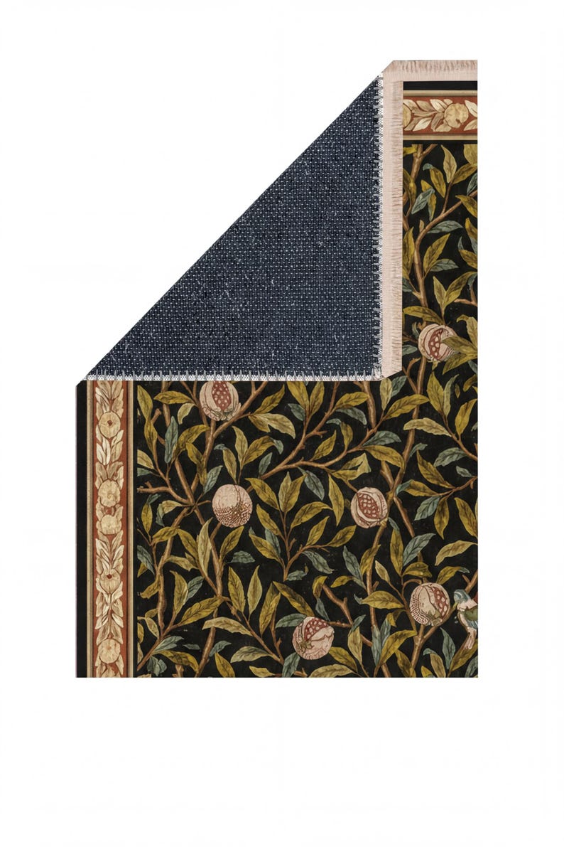 a close-up view of a rug with a floral pattern, including leaves and pomegranate fruits. The rug appears to be made of a dark-colored material, possibly wool or a similar fabric. The image does not contain any text or other discernible objects or actions.