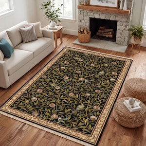 a cozy living room with a large rug featuring a green and black floral design, a white sofa, a fireplace, and a potted plant.