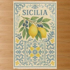 Puede incluir: Alfombra rectangular con fondo crema y diseño siciliano azul y amarillo. La alfombra presenta la palabra "SICILIA" en azul, junto con ilustraciones de limones, aceitunas y hojas. El borde tiene un fleco.