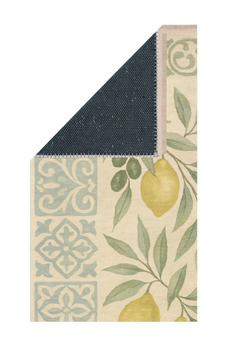 a decorative rug with a lemon and leaf pattern, and a dark blue geometric pattern on the left side.