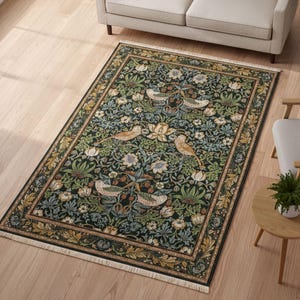 a large, intricately designed rug with a floral and bird motif, placed on a wooden floor in a living room setting.