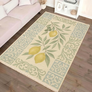 a living room with a large rug on the floor, which has a lemon and leaf design. The rug is placed next to a couch, and there are decorative pillows on the couch. The room also has a shelf with various items on it.