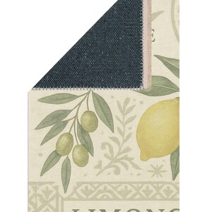 Pode incluir: Um tapete retangular com um design bot&acirc;nico com lim&otilde;es e azeitonas. O tapete tem um fundo creme com ilustra&ccedil;&otilde;es verdes e amarelas de frutas e folhas. A palavra "LIMONC" &eacute; vis&iacute;vel. A parte de tr&aacute;s do tapete &eacute; azul escuro.