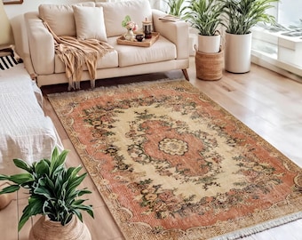 Alfombra vintage rosa con medallón floral y diseño clásico de borde oriental para sala de estar.
