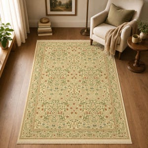 May include: A rectangular area rug featuring a dense, repeating botanical pattern in shades of sage green, muted terracotta, and cream. The design includes intricate floral motifs, scrolling vines, and leaves, finished with a short fringe on both ends.