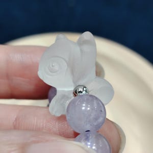 K&ouml;nnte beinhalten: Eine wei&szlig;e Keramik-Tasse mit schwarzem Henkel und dem Text "But First, Coffee" in fetter, schwarzer Schrift. Die Tasse steht vor einem verschwommenen Hintergrund, der eine gem&uuml;tliche Umgebung suggeriert.