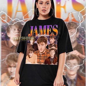 Puede incluir: Camiseta unisex negra con el nombre "JAMES" en una fuente retro morada y naranja. La camiseta presenta un collage de imágenes de una persona, con el nombre "Acasten" debajo del texto principal. La marca "TUTSHINE" también es visible.