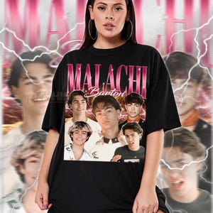 May include: Black unisex t-shirt with a pink, retro-style graphic of Malachi Barton and his name. The shirt has a vintage design with a collage of images of Malachi Barton. The text at the bottom describes the fit of the shirt.