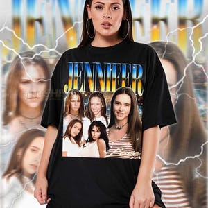 Peut inclure: T-shirt unisexe noir avec le nom "JENNIFER" dans une police rétro et un collage d'images. Le mot "Love" est en dessous des images. Le t-shirt est porté par une personne. Le t-shirt est de taille réelle.