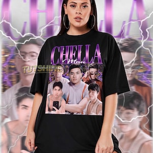 Op de afbeelding: Zwart unisex T-shirt met een afbeelding van een groep mannen en de tekst "CHELLA Man" in paars. Het shirt wordt gedragen door een persoon met oorringen. De achtergrond heeft een paars en wit ontwerp.