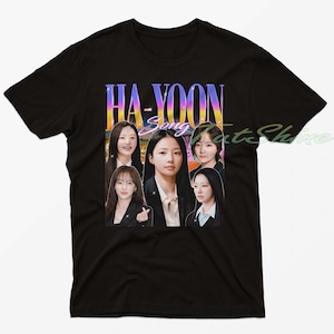 May include: Black t-shirt featuring a graphic of five women with the text "HA-YOON Song" in a colorful, retro font. The design has a vintage aesthetic, with a gradient background.