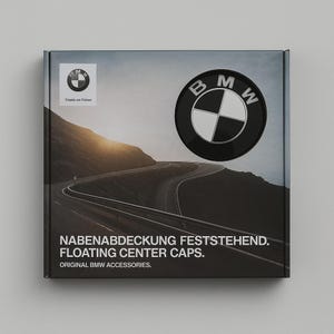 May include: A black box featuring the BMW logo and text. The logo is a black circle with a white and silver emblem. The box also displays the text "NABENABDECKUNG FESTSTEHEND. FLOATING CENTER CAPS. ORIGINAL BMW ACCESSORIES."