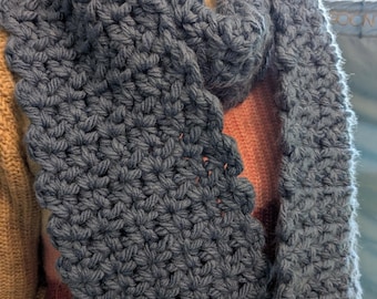 Puede incluir: Una bufanda infinita de crochet azul con un patrón de punto texturizado.