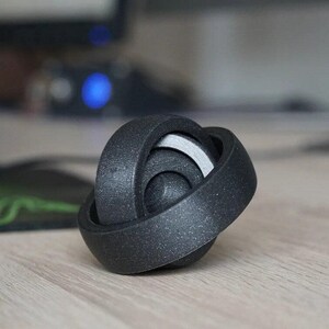Juguete antiestrés con anillos giratorios impreso en 3D que alivia el estrés y mejora la concentración.