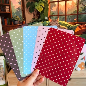May include: A set of five rectangular cards arranged in a fan shape, each featuring a solid background colour with a repeating white polka dot pattern. The colours include dark brown, sage green, light blue, soft pink, and a vibrant deep red.