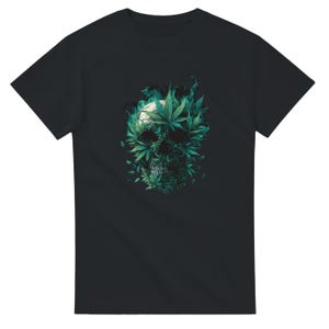 Könnte beinhalten: Schwarzes T-Shirt mit einem Totenkopf-Design aus grünen Cannabisblättern. Der Schädel hat einen weißen Hintergrund und ist von grünen rauchartigen Akzenten umgeben. Das Design ist mittig auf der Vorderseite des T-Shirts platziert.