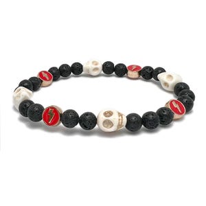 May include: Black lava rock and white skull beads with red and gold lightning bolt accents form a bracelet.