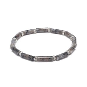 May include: A gray and silver bracelet with small, round stones set in silver.