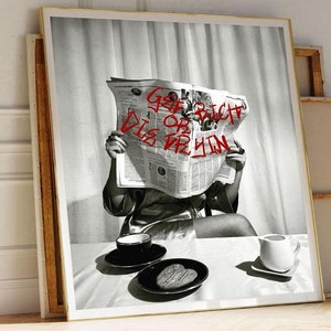 May include: A black and white photo of a person in a robe reading a newspaper with the words "Go or Rich Die or Tryin" written in red on the front page. The person is sitting at a table with a cup of coffee and a plate of cookies.