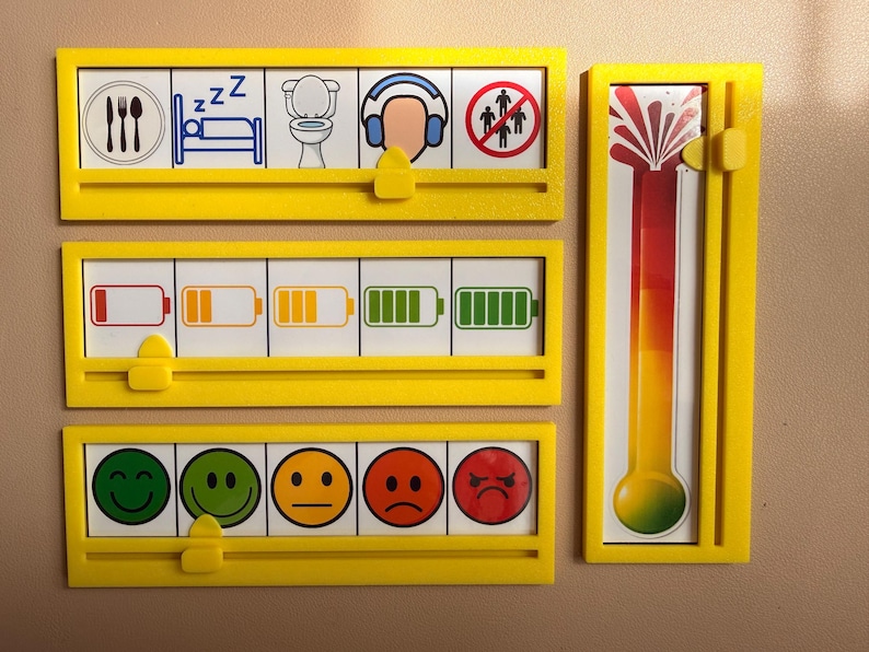May include: Three horizontal yellow plastic frames with sliding tabs and one vertical yellow frame with a sliding tab. The frames contain visual communication cards showing daily activities, battery charge levels, emotional faces, and a color-coded thermometer.