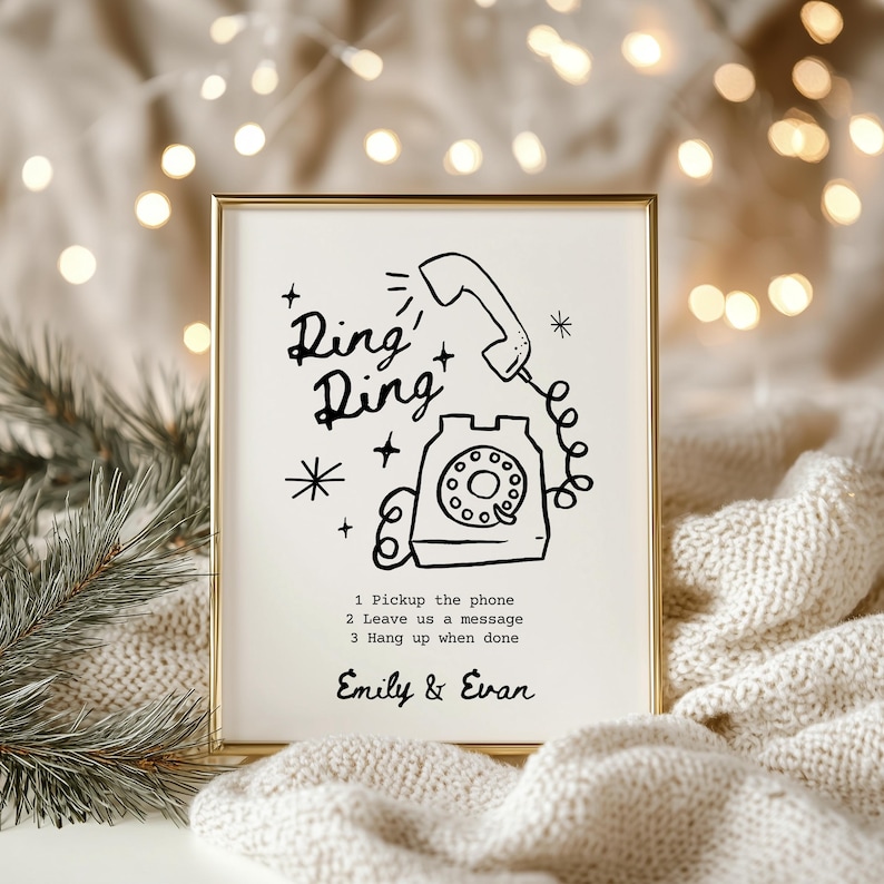 May include: A black and white illustration of a rotary phone with the text "Ring+Ring" above it. The illustration is on a white background with a gold frame. The text below the illustration reads "1 Pickup the phone 2 Leave us a message 3 Hang up when done" and "Emily & Evan".