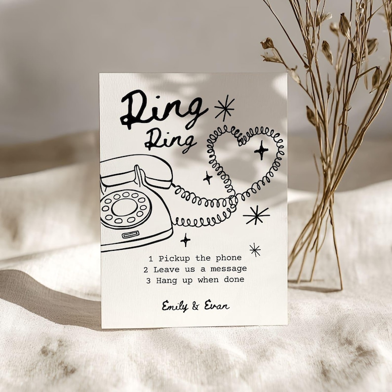 May include: A cream-colored card with a black line drawing of a vintage telephone, a heart-shaped cord, and the words "Ding Ring." Text below reads "1 Pickup the phone, 2 Leave us a message, 3 Hang up when done." The names "Emily & Evan" are at the bottom.