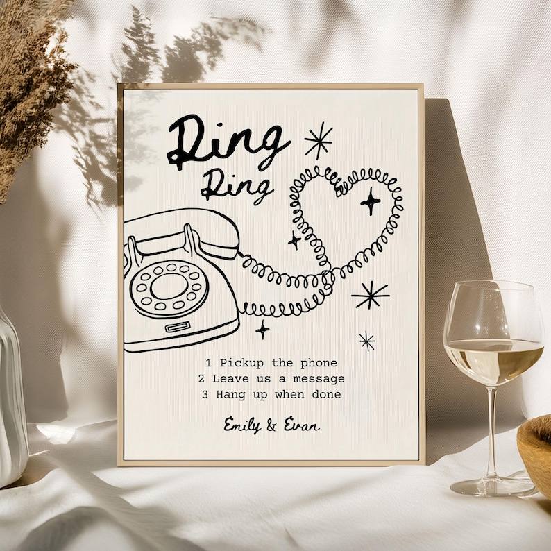 May include: A framed print with the words "Ring Ring" above a vintage telephone illustration. The phone cord forms a heart shape. Text below reads "1. Pickup the phone, 2. Leave us a message, 3. Hang up when done." Signed "Emily & Evan."