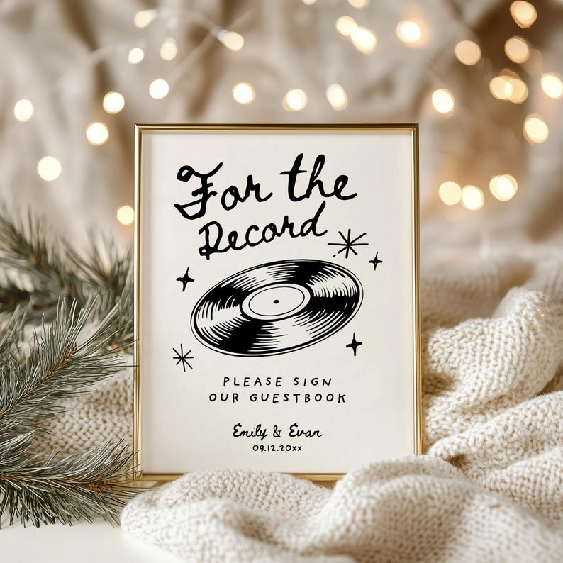 May include: A white sign with a gold frame, featuring a black and white illustration of a vinyl record with the text "For the Record" and "Please sign our guestbook". The sign also includes the names "Emily & Evan" and the date "09.12.20XX".