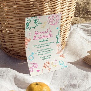 Pode incluir: Um cart&atilde;o branco com um design ilustrado em rosa, verde e amarelo. O texto no cart&atilde;o diz "Hannah's Bachelorette weekend" e inclui detalhes para uma despedida de solteira.