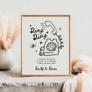 May include: A black and white illustration of a rotary phone with the text "Ring Ring" and instructions to "Pickup the phone", "Leave us a message", and "Hang up when done". The names "Emily & Evan" are printed below the instructions.