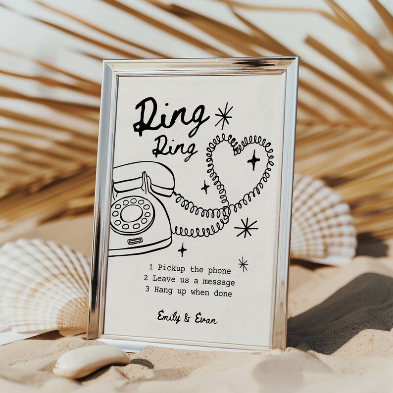 May include: A framed print with a silver border featuring a vintage telephone illustration. The text "Ring Ring" is above the phone, with instructions below: "1 Pickup the phone, 2 Leave us a message, 3 Hang up when done." The names "Emily & Evan" are at the bottom.